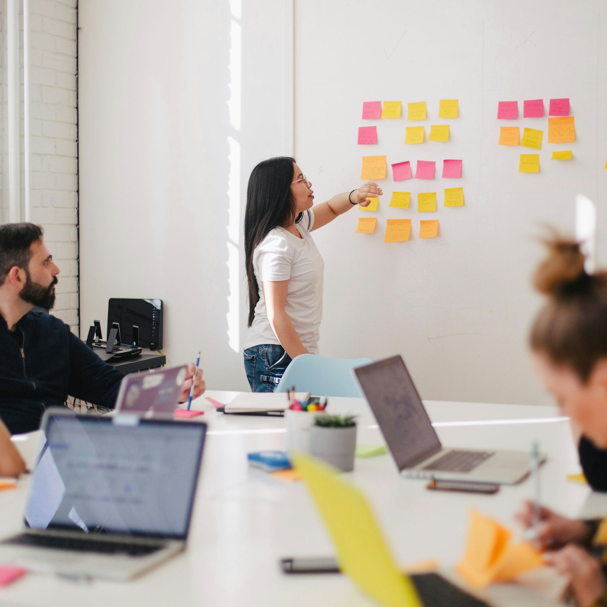 A team planning work on a whiteboard covered in sticky notes